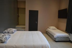 1 dormitorio con 2 camas y puerta negra en Hôtel Timgad en Gérardmer