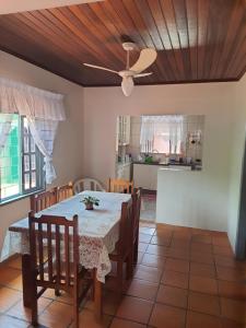 a dining room with a table and a ceiling fan at Leal house in Matinhos