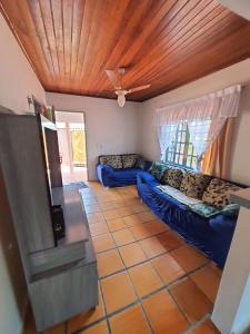 a living room with blue couches and a wooden ceiling at Leal house in Matinhos