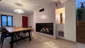a dining room with a table and a fireplace at Hôtel Gîte La Bonaventure Jezainville in Jezainville