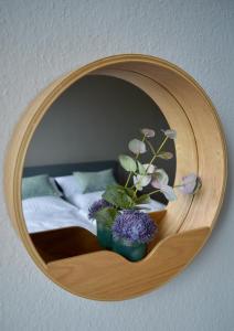 un espejo redondo de madera con flores en un dormitorio en RHEIN-SUITES BOPPARD, en Boppard