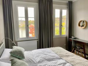 a bedroom with a bed and a desk and windows at RHEIN-SUITES BOPPARD in Boppard