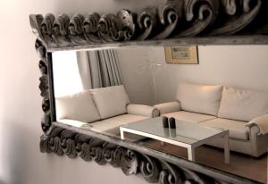 a living room with a couch and a mirror at Moderne Ferienwohnung Primavera in Colonia Sant Jordi