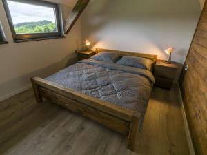 a bedroom with a wooden bed with a window at Apartmán pod Pustým vrchem in Říčky