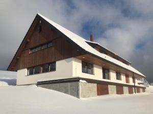 a building in the snow with snow on the ground at Apartmán pod Pustým vrchem in Říčky