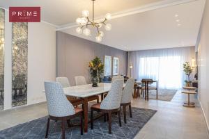 a dining room with a table and chairs at Prime Select Palm Hills - The Crown in Abū Rawwāsh