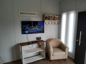 a living room with a chair and a television on a wall at Casita de Piedra 4 in Trinidad