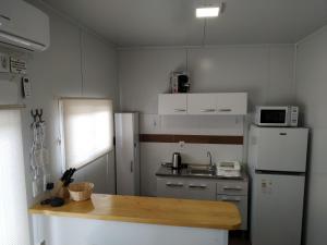 a small kitchen with a refrigerator and a table at Casita de Piedra 4 in Trinidad