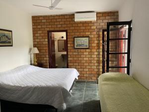 a bedroom with two beds and a brick wall at Barequeçaba Praia Hotel in Barequeçaba +77 photos