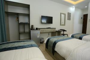 a hotel room with two beds and a television at Down Town Hotel in Aqaba