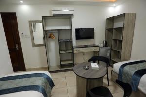 a hotel room with two beds and a table and a tv at Down Town Hotel in Aqaba