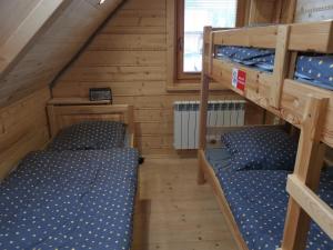 Poschodová posteľ alebo postele v izbe v ubytovaní Štýlový Zrub Martina A s kúpacou Kaďou a detským ihriskom!