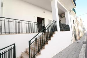 een wit gebouw met een trap en een deur bij Casa Vacanza Glenda Otranto in Otranto