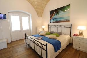 een slaapkamer met een groot bed met een blauwe deken bij Casa Vacanza Glenda Otranto in Otranto