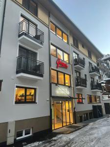 un immeuble d'appartements avec un panneau sur son côté dans l'établissement Hotel Grieserin, à Sankt Anton am Arlberg