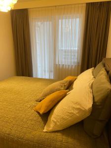 een slaapkamer met een bed met kussens en een raam bij Northastic Suite in Oostende