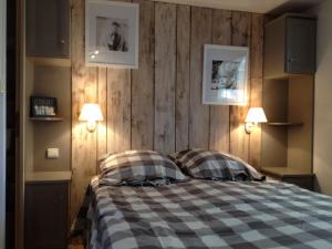 a bedroom with a bed with a checkered blanket at Mobilhome St Tropez 5H02 in Saint-Tropez
