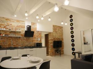 ein Wohnzimmer mit einem Tisch und eine Küche mit Platten an der Wand in der Unterkunft Art Vinyl Loft in Białystok