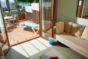 ein Wohnzimmer mit einem Sofa und einer Terrasse in der Unterkunft Grupotel Flamingo Beach in Playa Blanca