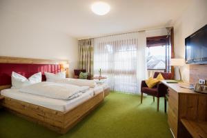 a hotel room with a large bed and a desk at Hotel & Gasthaus Zum Hirschen in Staufen im Breisgau