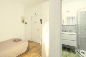 a white bathroom with a bed and a sink at GARDEN HOUSE - Luxury Guest House - Self check-in only in Rome