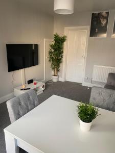 Stylish & Convenient في بلفاست: غرفة معيشة مع طاولة بيضاء وكرسيين