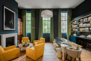 a living room with blue walls and a table and chairs at Cheval Old Town Chambers in Edinburgh