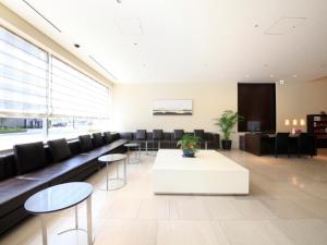 eine große Lobby mit einem weißen Tisch und Stühlen in der Unterkunft Richmond Hotel Fukushima Ekimae in Fukushima