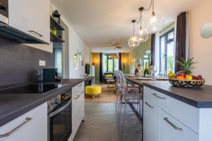 a kitchen with white cabinets and a counter top at Les Cerisiers Beach Residence, Cosy and Modern 3 bedroom apartment located 50 metres from the beach and from all amenities and restaurants on the coastal road in Flic-en-Flac