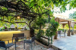 a patio with chairs and tables under a pergola at GARDEN HOUSE - Luxury Guest House - Self check-in only in Rome