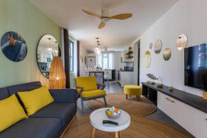 a living room with a blue couch and yellow chairs at Les Cerisiers Beach Residence, Cosy and Modern 3 bedroom apartment located 50 metres from the beach and from all amenities and restaurants on the coastal road in Flic-en-Flac