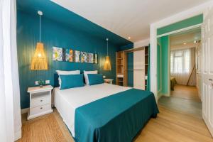 a bedroom with a large bed with blue walls at Les Cerisiers Beach Residence, Cosy and Modern 3 bedroom apartment located 50 metres from the beach and from all amenities and restaurants on the coastal road in Flic-en-Flac +56 photos