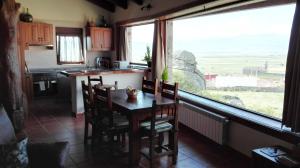 a kitchen with a table and chairs and a large window at Entre las Piedras y musgo in Muñopepe