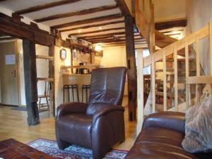 - un salon avec un fauteuil en cuir et un canapé dans l'établissement Historisches Haus im Herzen von Monschau, à Monschau