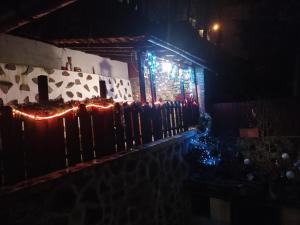 a fence with christmas lights in front of a house at Gloria Apartments in Sighişoara