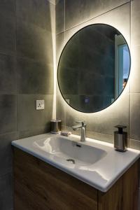 a bathroom with a sink and a mirror at Les Cerisiers Beach Residence, Cosy and Modern 3 bedroom apartment located 50 metres from the beach and from all amenities and restaurants on the coastal road in Flic-en-Flac