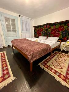 a bedroom with a bed with two rugs at Casa Fântâna - La poalele muntilor -50 de metri de pârtia Olimpică in Statiunea Borsa