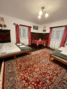 Sala de estar con 2 camas y mesa en Casa Fântâna - La poalele muntilor -50 de metri de pârtia Olimpică, en Statjunea Borsa