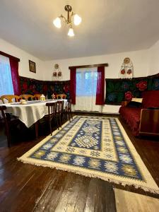 een woonkamer met een tapijt op de vloer bij Casa Fântâna - La poalele muntilor -50 de metri de pârtia Olimpică in Statjunea Borsa