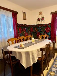 uma sala de jantar com uma mesa branca e cadeiras em Casa Fântâna - La poalele muntilor -50 de metri de pârtia Olimpică em Statjunea Borsa