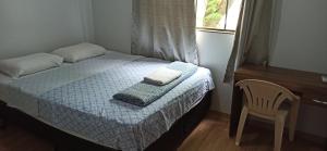 een slaapkamer met een bed met twee handdoeken erop bij D'Casa Hotel e restaurante in Marechal Cândido Rondon