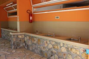 a public bathroom with three sinks and a fire extinguisher at Camping Planik in Ražanac +123 photos