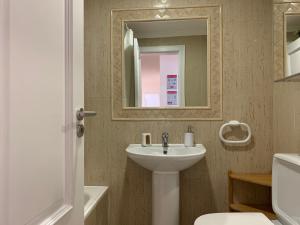 a bathroom with a sink and a mirror at Monte Gordo Beach Flat with Balcony in Monte Gordo +20 photos