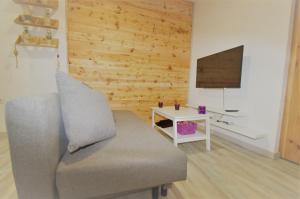een woonkamer met een bank en een televisie bij Apartamento Blue Ice in Tarifa