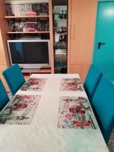 a dining room table with blue chairs and a television at Landhaus Studio in D 63667 Nidda, Gäßchen 8 Erdgeschoss links in Nidda