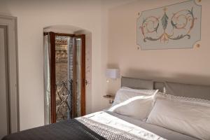 a bedroom with a bed with white sheets and a mirror at Brunelli Appartamenti in Assisi