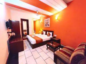 um quarto de hotel com uma cama e um sofá em Hotel Unistar em Nova Deli