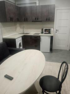 a kitchen with a table and a chair and a sink at Як вдома ! in Uzhhorod +10 photos
