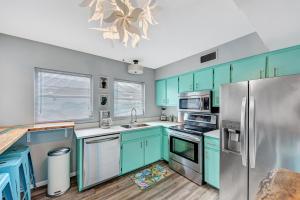Bee RidgeにあるShark Unit, Pool Jacuzzi Steps to Siesta Key Beachのキッチン(青いキャビネット、ステンレス製の冷蔵庫付)