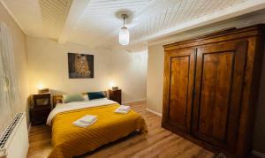 a bedroom with a bed with a yellow blanket at La Ferme de Madeleine in Fessenheim-le-Bas